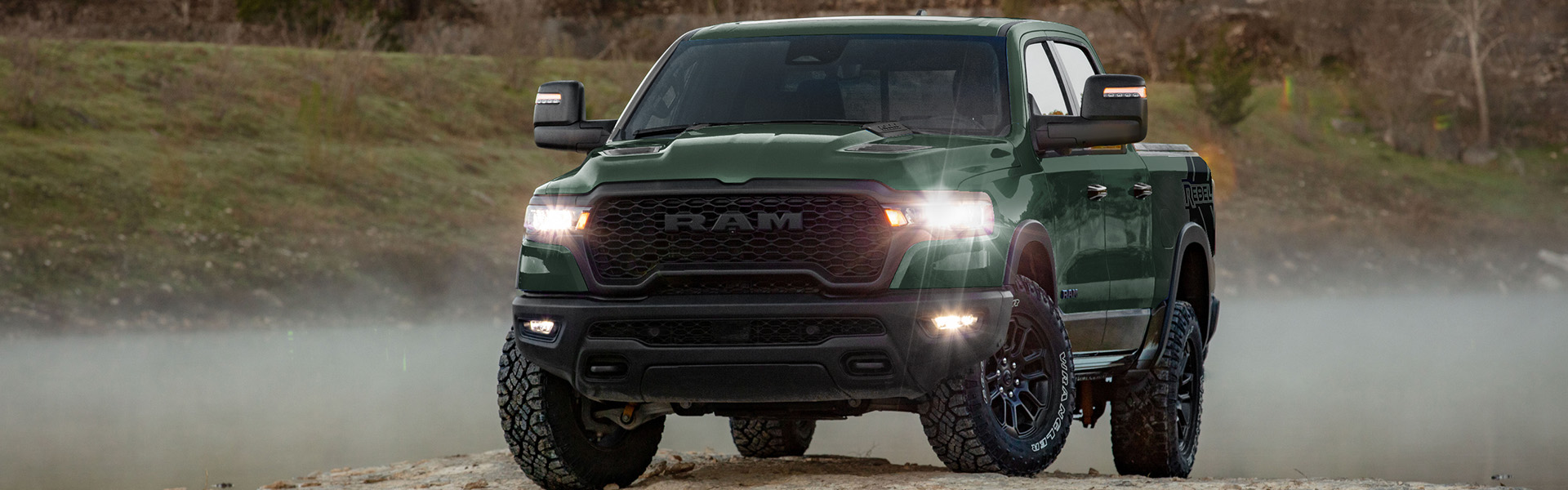 A Ram 1500 pickup truck parked in a muddy field, showcasing its rugged design and off-road capabilities.
