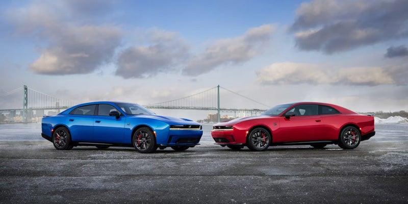 A Dodge Charger and a Dodge Challenger parked side by side, showcasing their sleek designs and sporty features.
