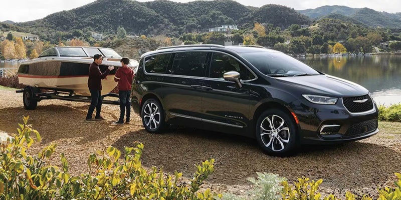 Chrysler Pacifica parked beside a boat, showcasing its spacious design and versatility for family outings.
